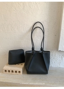 Detail view of black pebbled leather tote bag set including a matching zipper pouch