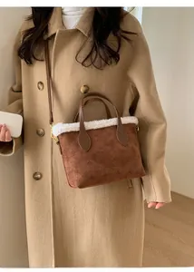 Detail of plush lamb wool trim and embossed patterns on a brown faux suede bucket bag