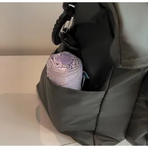 Détail de la poche latérale durable du fourre-tout noir avec un parapluie violet à l'intérieur