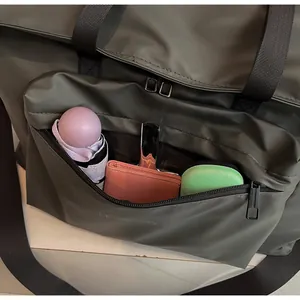 Gros plan sur la poche zippée avant du sac fourre-tout imperméable vert foncé
