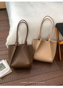 Close-up of minimalist retro tote bags featuring knotted handles and荔枝 grain leather texture