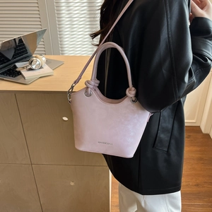 Close-up of the light pink bucket bag showing marble texture and tied handle detail