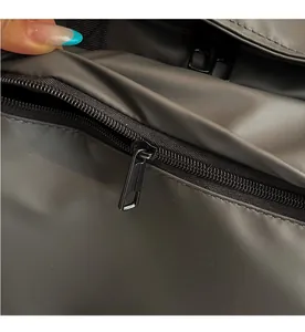 Détail de la fermeture éclair en métal noir et du logo LEENO sur le sac gris foncé