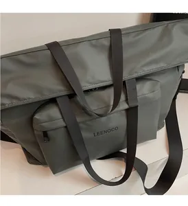Détail des poignées tissées et de la bandoulière de ce grand sac fourre-tout vert foncé