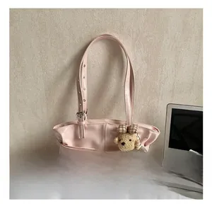 Detail of light pink tote bag with silver buckle and cute plush bear charm accessory