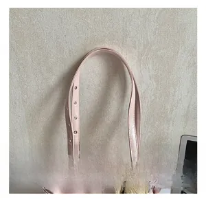 Detail of adjustable pink leather strap with metal buckle and plush bow charm