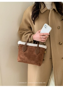 Detailed close-up of brown suede bucket bag with white plush trim and leather handles