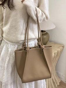 Elegant khaki tote bag with knot strap detail and textured finish for daily commute