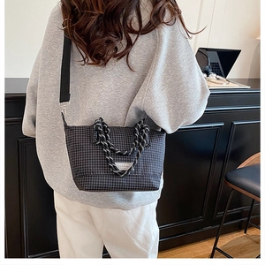 Detail of checkered tote bag with woven rope handles and adjustable nylon shoulder strap
