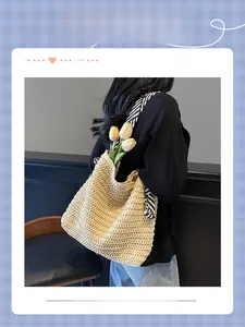 Detail of large straw tote bag with elegant black and white striped scarf strap and tulips