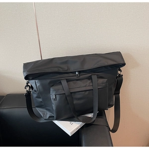 Détail du sac fourre-tout en nylon noir étanche avec logo LEENOCO et bandoulière réglable