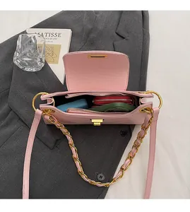 Detailed view of pink chain bag interior showing main compartment and zippered pocket