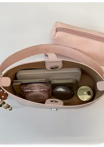 Detail of light pink faux leather tote bag interior with magnetic snap and inner pouch