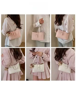Detail showing white and pink lychee leather shoulder bags with cute plush bear charms
