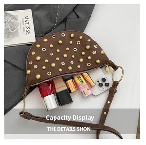 Brown leather half-moon shoulder bag with gold studs showing its large interior capacity