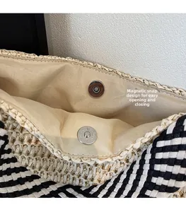 Detail of magnetic snap closure and woven lining inside a beige straw tote bag
