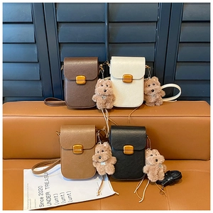 Detail view of four mini crossbody bags in brown, beige, khaki and black with puppy charms