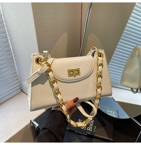 Détail d'un sac blanc en cuir texturé avec une boucle à fermoir tournant dorée