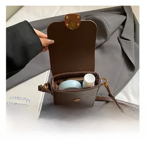 Detail view of small dark brown vintage crossbody bag showing internal storage capacity