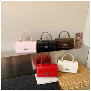 Detail showing crocodile texture leather handbags with silver turn-lock in five colors