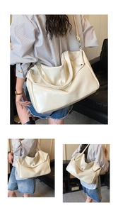 Close-up of a large cream glossy leather tote bag with rivet details and shoulder strap