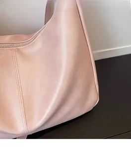 Close-up of soft nude pink faux leather tote with smooth silver zipper and fine stitching