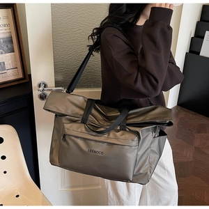 Détail d'un sac cabas métallique avec texture en nylon et bandoulière réglable pratique