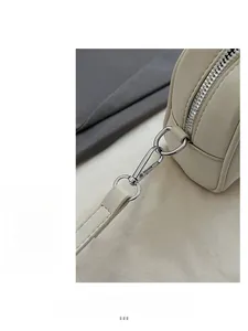 Dettaglio del gancio in metallo argento e cuciture su una borsa in pelle beige