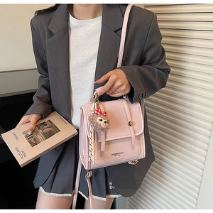 Lifestyle view of a pink retro backpack with plush charm and golden hardware details
