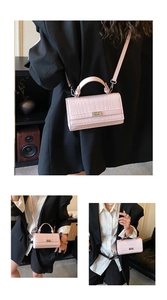 Detailed macro view showing the light pink crocodile skin texture and metallic lock buckle