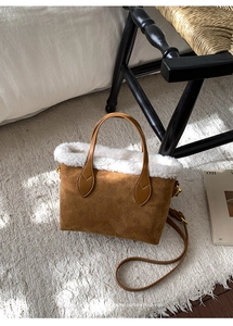 Brown suede handbag with star embossing and white plush trim on a cream rug