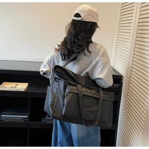 Détail d'un grand sac fourre-tout noir en nylon imperméable avec bandoulière réglable