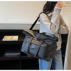 Vue détaillée du sac cabas en nylon noir avec poches multiples et logo de LEENGCO