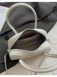 Dettaglio borsa bowling in pelle PU crema con cerniera argento e tracolla staccabile inclusa