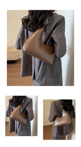 Détail de la texture en cuir marron foncé et de la bandoulière réglable d'un sac hobo