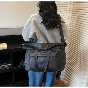 Détail du grand sac noir imperméable avec logo de marque et bandoulière réglable large
