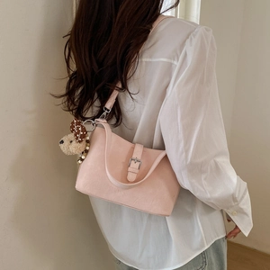 Detail showing pink matte shoulder bag worn by model with cute teddy bear charm