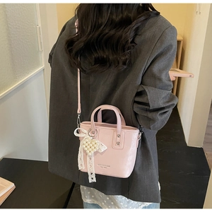 Detailansicht der rosa Beuteltasche mit Perlenherz und Spitzenschleife am Model