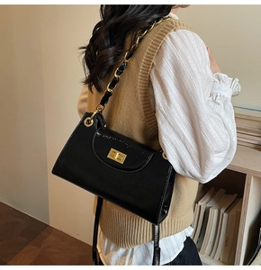 Sac à bandoulière chic en cuir verni noir avec chaîne dorée et fermoir métallique