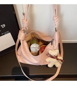 Detail of spacious pink leather tote interior with secure silver zipper and soft bear charm