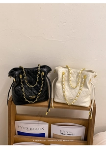 Vue détaillée de sacs seaux matelassés avec bandoulière chaîne dorée et cordon de serrage