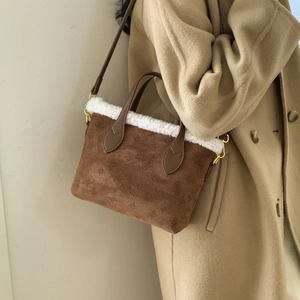 Brown suede tote bag with white faux fur trim and embossed patterns on camel coat