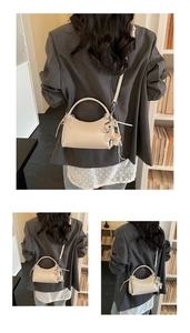 Detalle de bolso media luna crema con colgante de caballo y correa de hombro fina