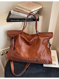 Vintage brown leather tote bag with punk rivets, tassels, and spacious interior