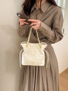 Détail du sac seau blanc matelassé avec poignée chaîne dorée et logo Pan'tor London
