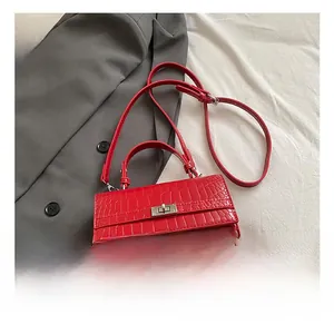 Detail showing red crocodile pattern handbag with elegant metal twist lock and top handle