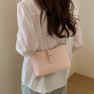 Fashionable soft pink underarm bag with silver buckle detail shown on female model