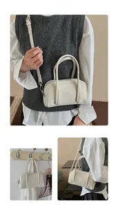 Dettaglio della borsa a cuscino retrò bianco sporco con texture opaca e fibbie