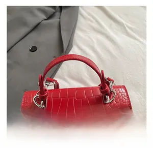 Detail shot of red crocodile embossed handbag with polished silver metal twist lock clasp