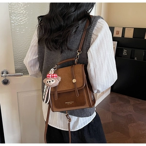Detail shot of vintage contrast color backpack with ShellieMay charm on the side